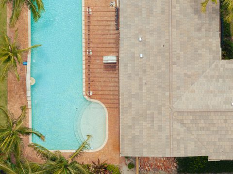 Aerial view of pool and house with roof in west palm beach fl