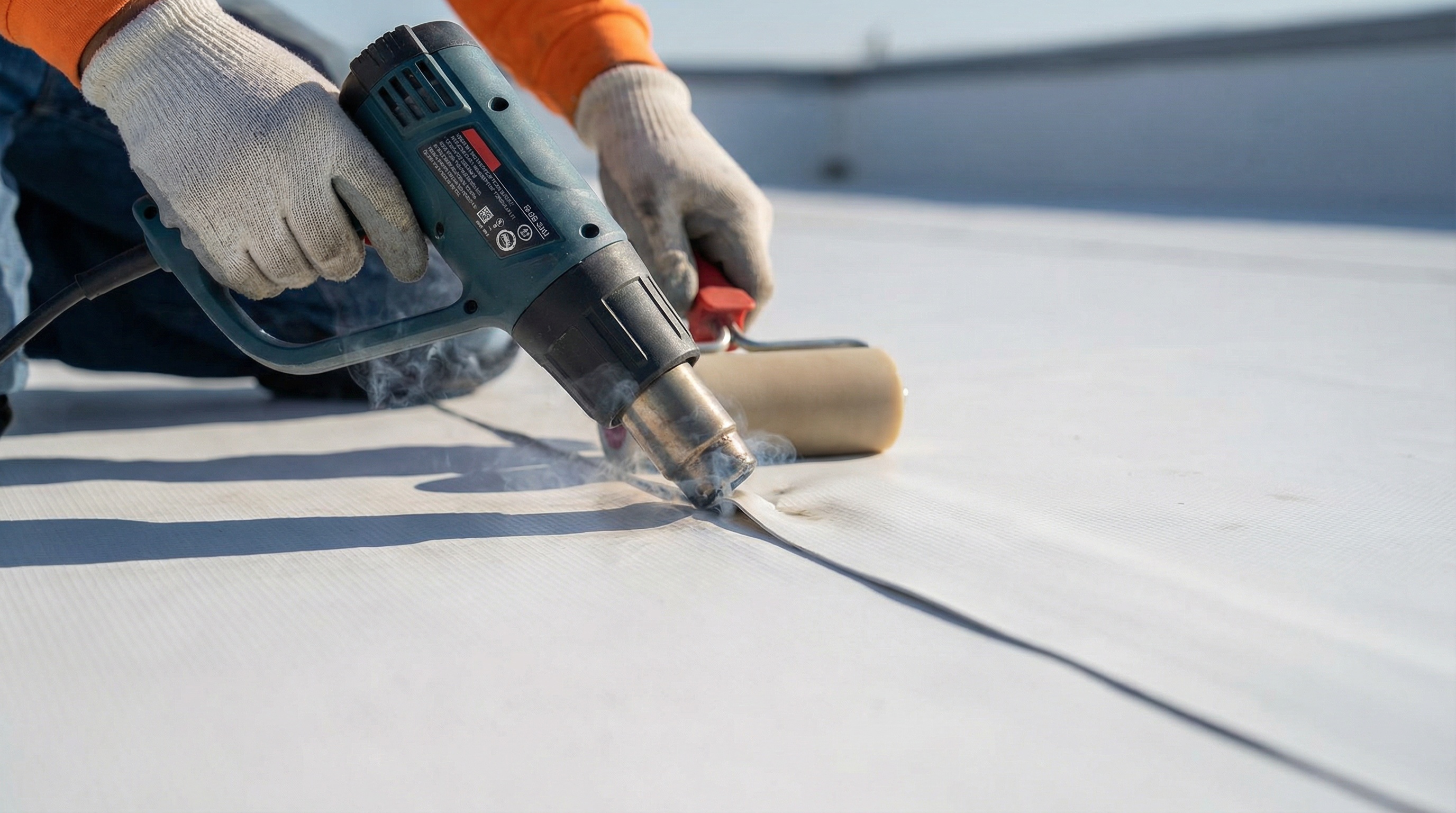 Close-up view of TPO membrane seam welding process showing heat gun application