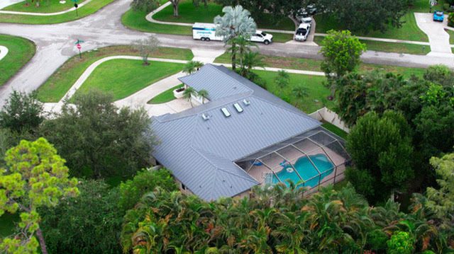 Aerial view of suburban house roof and pool in jupiter
