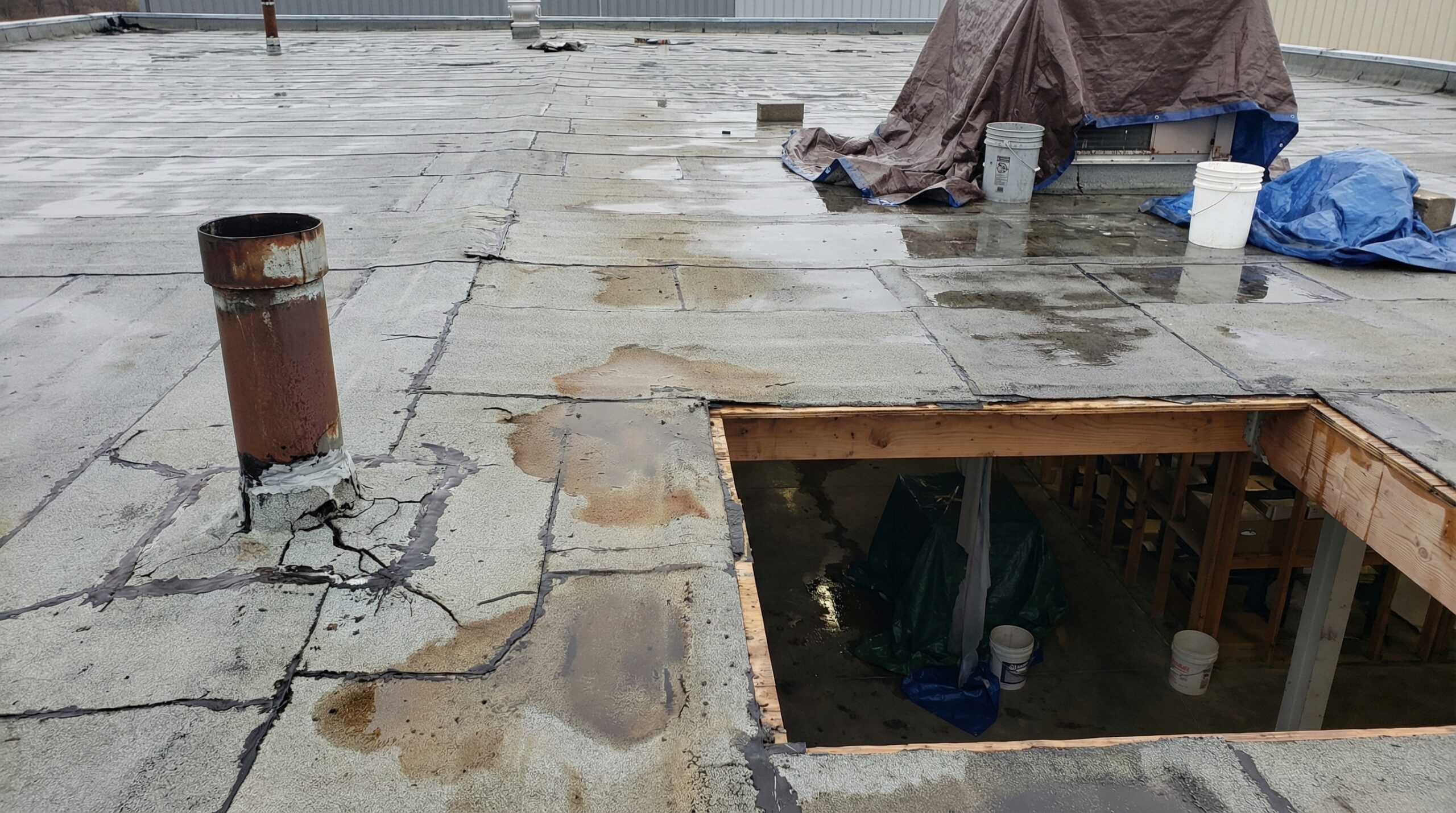 damaged commercial roof showing improper installation with visible leaks and poor workmanship