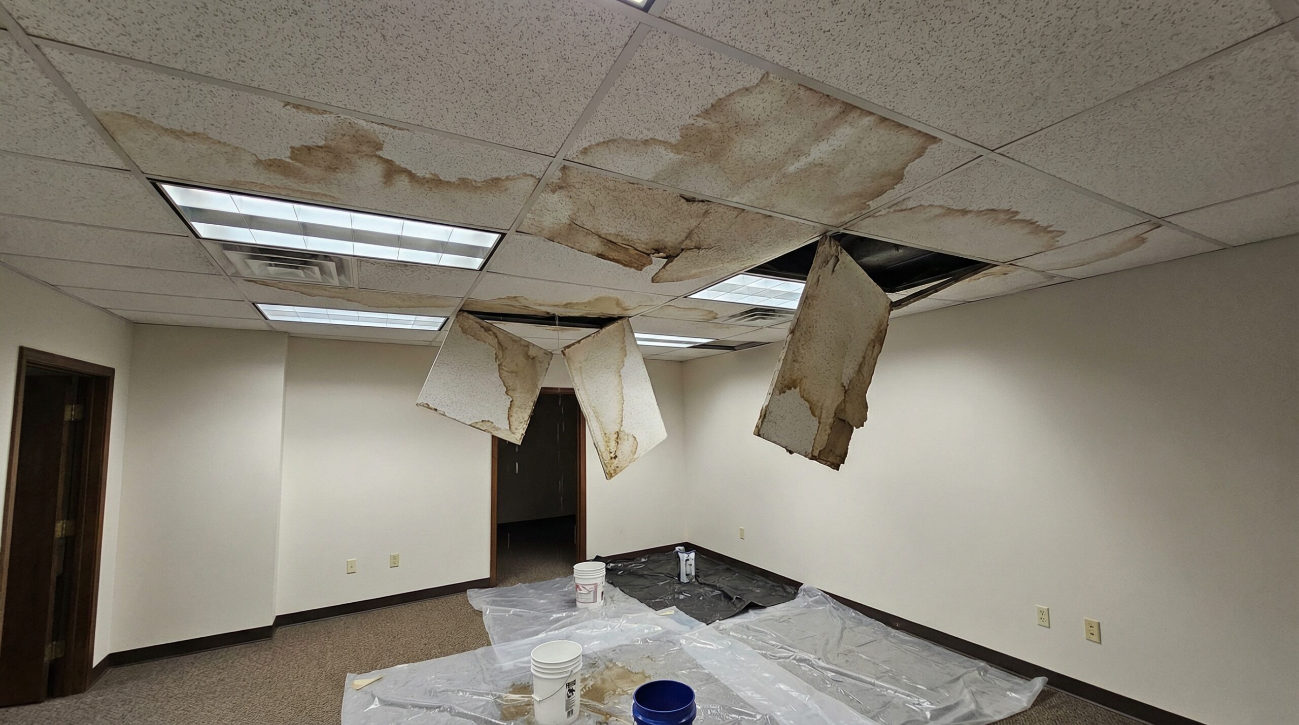 Water damage in commercial building interior with ceiling stains