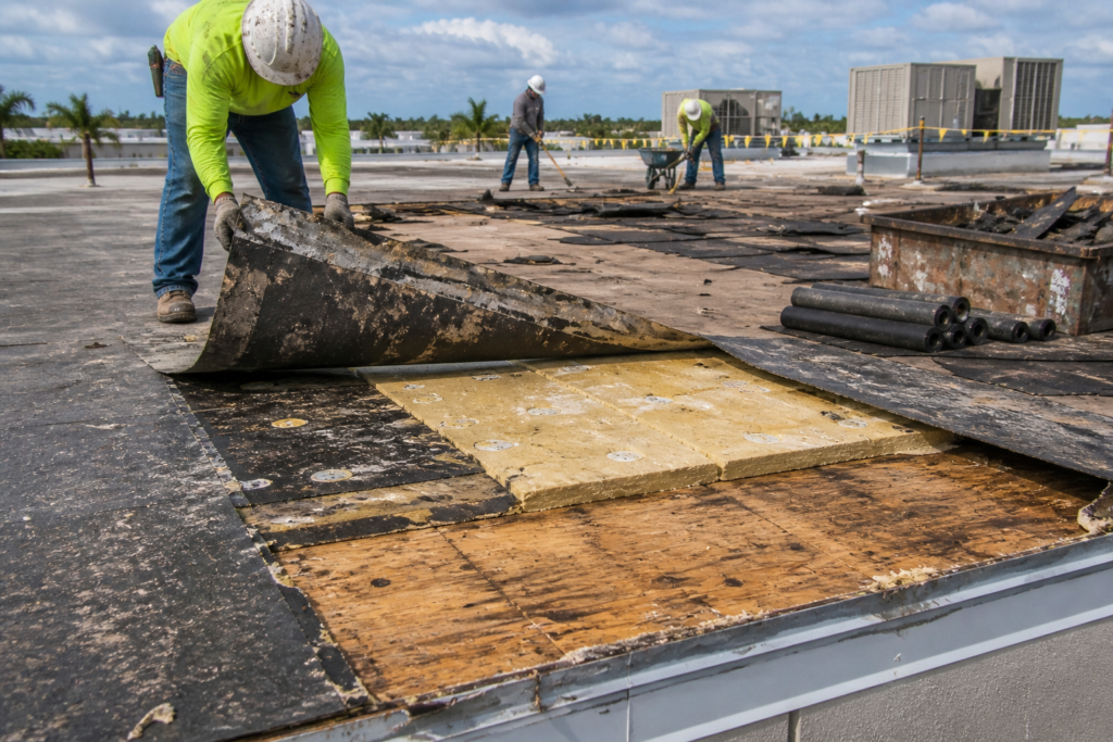 Workers removing old roofing material