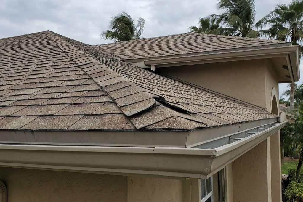 Damaged roof shingles from wind
