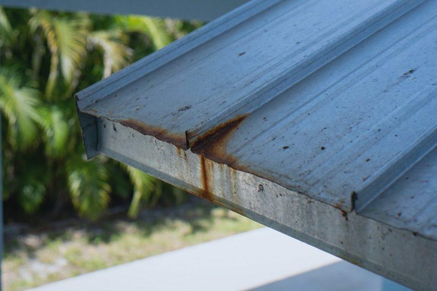 Rust bleeding from the cut edge and seam of a metal roof panel exposed to salt air in South Florida